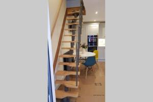 a wooden spiral staircase in a kitchen with a table at Riverside Lodge Pied a Terre in Fordingbridge +20 photos