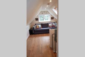 a living room with a couch and a window at Riverside Lodge Pied a Terre in Fordingbridge