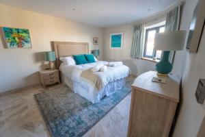 a bedroom with a bed and a table with a lamp at The Breakers in Brancaster