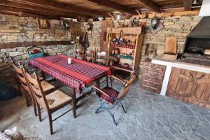 a table and chairs in a room with a stone wall at Guest House "Villa YANA" in Golyama Zhelyazna