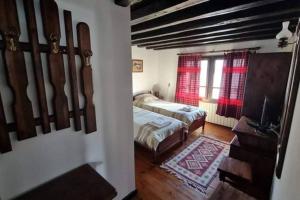 a bedroom with two beds and a window at Guest House "Villa YANA" in Golyama Zhelyazna