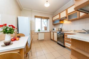 eine Küche mit einem Kühlschrank und einem Tisch mit Obst darauf in der Unterkunft Уютная квартира на Оболонском проспекте у метро in Kiew