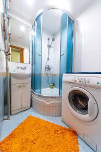 ein Bad mit einer Waschmaschine und einer Dusche in der Unterkunft Уютная квартира на Оболонском проспекте у метро in Kiew