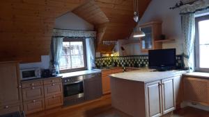 eine große Küche mit Holzschränken und einer Arbeitsplatte in der Unterkunft Ferienhaus und Apartment Idolsberg in Idolsberg