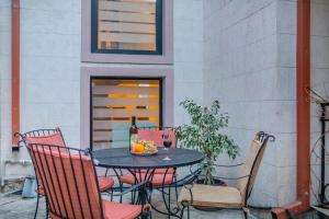 a table with chairs and a bottle of wine and fruit at Gala Boutique Hotel in Kutaisi