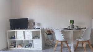- un salon avec une table, des chaises et une télévision dans l'établissement Nissa La Bella, à Nice