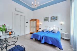 Un dormitorio con una cama azul y una mesa en Soggiorno Isabella De' Medici, en Florencia