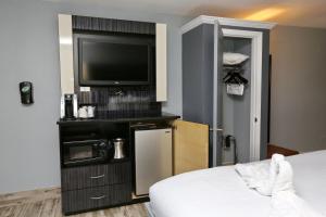 a room with a bed and a flat screen tv at Historic Waterfront Marion Motor Lodge in downtown St Augustine in St. Augustine