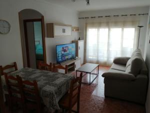 a living room with a table and a couch and a television at Apartamento Paraíso en Santa Pola in Santa Pola