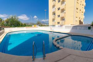 een groot zwembad voor een gebouw bij Elegante apartamento en Playa de Gandía in Playa de Gandia