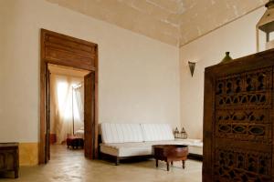 uma sala de estar com um sofá branco e uma mesa em La Casa Dell'Arancio em Favignana