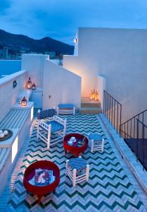 a balcony with chairs and tables on a building at La Casa Dell'Arancio in Favignana