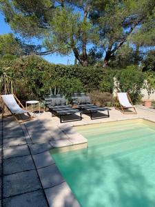 a swimming pool with chairs and a table and a table and chairs at Maison Les Chênes in Eygalières +51 photos