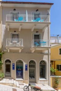 a building with a balcony and a bike parked in front at LOC HOSPITALITY Urban Suites in Corfu Town