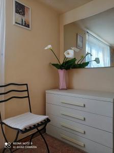ein Schlafzimmer mit einer Kommode und einer Vase mit Blumen darauf in der Unterkunft Il Giardino di Patrizia in Querceta