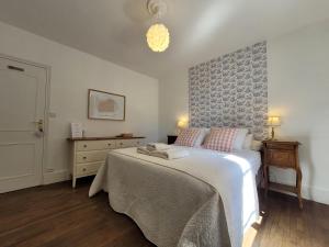 a bedroom with a bed and a dresser and a lamp at Les Portails Bleus in Azé