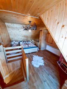 an attic room with a bed and a staircase at Chatka Gaździnek in Czarna Góra