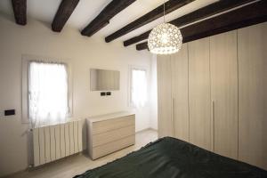 a bedroom with a bed and a chandelier at Dimora Marchiada -apeliving- Pellestrina Ve in Pellestrina