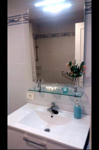 a bathroom sink with a glass shelf above it at Charming Holidays in Martiánez Beach in Puerto de la Cruz