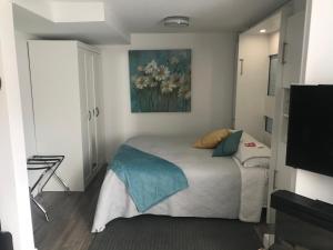 1 dormitorio con 1 cama con una pintura en la pared en le Loft Québec en Quebec