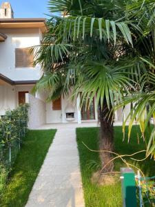 a palm tree in front of a house at Villa delle Terme in Lignano Sabbiadoro