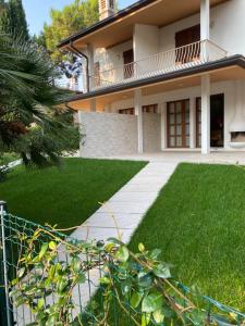 a large house with a green lawn in front of it at Villa delle Terme in Lignano Sabbiadoro