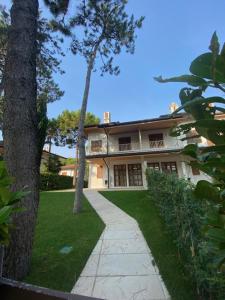 a large house with a walkway in front of it at Villa delle Terme in Lignano Sabbiadoro