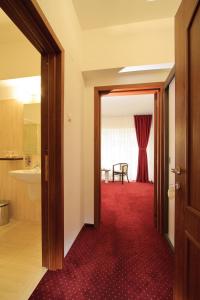 una puerta abierta a una habitación con alfombra roja en Hotel President en Băile Olăneşti