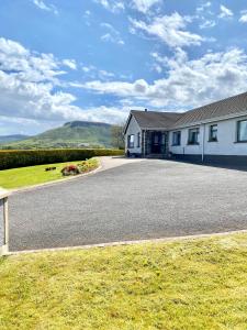 ein Haus mit einer großen Einfahrt davor in der Unterkunft Cullentra House in Cushendall