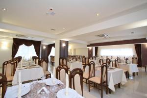 un salón de banquetes con mesas y sillas en una habitación en Hotel President en Băile Olăneşti