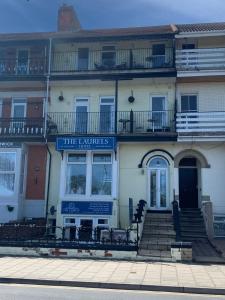 um edifício branco com um sinal azul em The Laurels Hotel em Skegness
