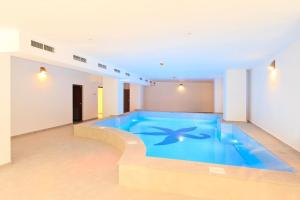 a large blue swimming pool in a building at Hotel President in Băile Olăneşti