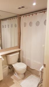 een badkamer met een toilet en een douchegordijn bij Toronto Luxury Accommodations - University Plaza in Toronto