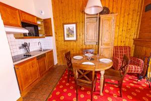 kuchnia z drewnianym stołem z krzesłami i zlewem w obiekcie Arc 1950 - Charmant appartement 2-4 personnes dans résidence hôtelière w mieście Bourg-Saint-Maurice