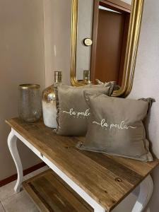 un tavolo con cuscini e uno specchio di Hotel La Perla a Lignano Sabbiadoro