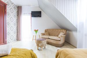a living room with a couch and a chair at Gościniec Pod Lipą in Mikołajki