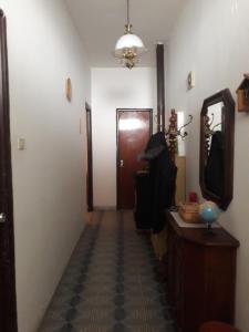 pasillo de una habitación con puerta y espejo en Casetta in centro en Soveria Simeri