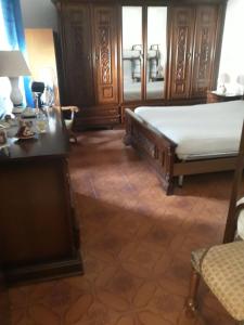 a bedroom with a bed and a dresser and a table at Casetta in centro in Soveria Simeri
