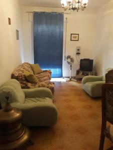a living room with two couches and a television at Casetta in centro in Soveria Simeri
