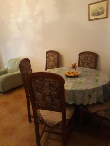 un comedor con una mesa con sillas y un bol de fruta. en Casetta in centro en Soveria Simeri