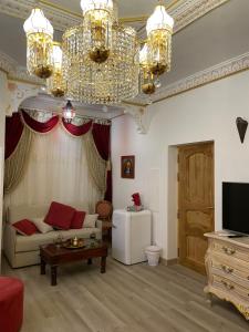 a living room with a couch and a chandelier at Suite Orientale Maison de L'église du Couvent in Narbonne