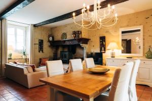 Un comedor con una mesa de madera y sillas blancas. en B&B Eth Béryè Petit, en Beaucens