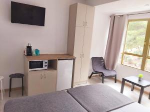 a bedroom with a bed and a kitchen with a microwave at Casa Durán Alicante in Alicante