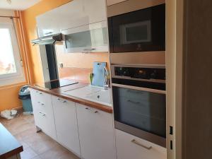 克雷伊的住宿－Dans grand appart de 113m2 proche Paris，厨房配有白色橱柜和炉灶烤箱。