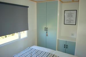 a bedroom with a bed and a glass shower at Chalet Wiron aan het Wad. in Westerland