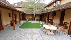 a patio with a table and chairs and a lawn at Gellény Lux Apartman in Gyula