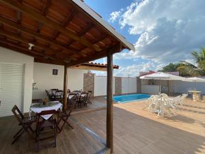 a wooden deck with tables and chairs on a house at Pousada Nova Estrela da Canastra in Delfinópolis +39 photos