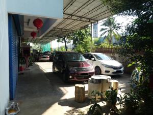 two cars parked in a parking lot next to a building at TIT MOTEL in Sungai Petani