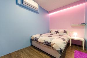 羅東鎮的住宿－遇見小太陽，一间卧室配有一张紫色墙壁的床