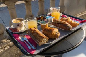 een tafel met een dienblad met brood en sinaasappelsap bij Hôtel Central in Poitiers